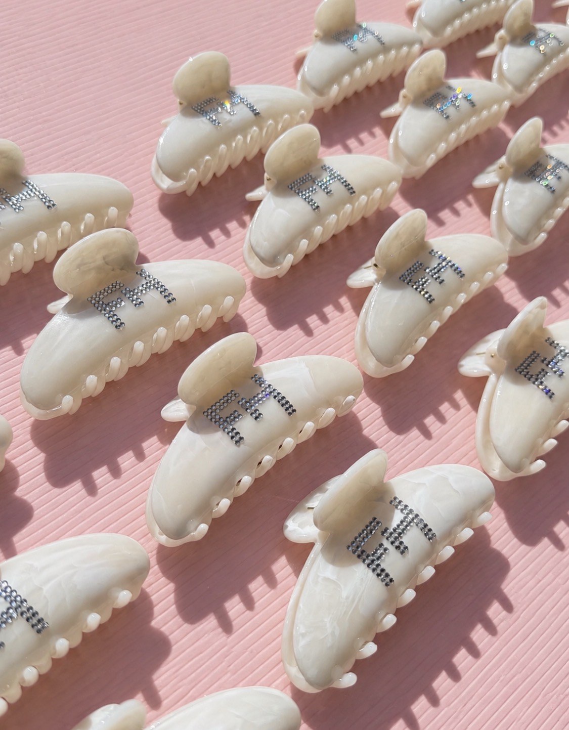 Custom cream clips displayed on pink